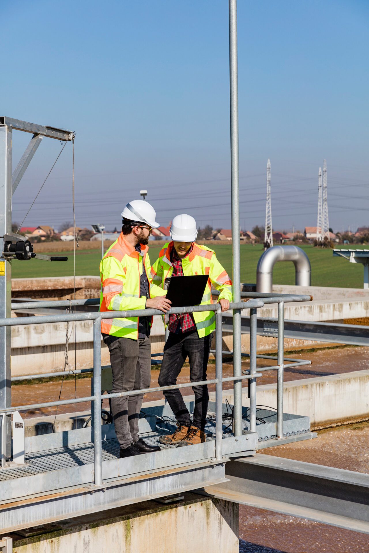 Engineers working on water treatment plant with laptop and measuring sensors